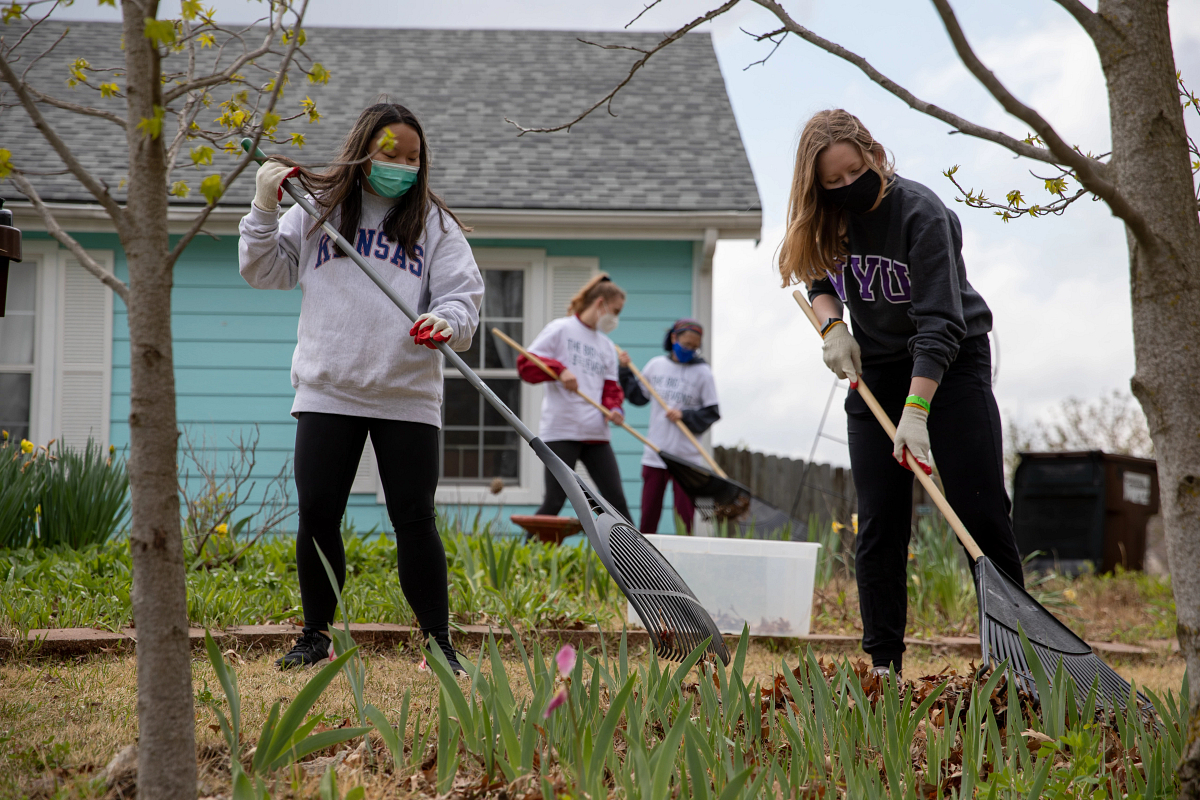 Student volunteers raking leaves at The Big Event